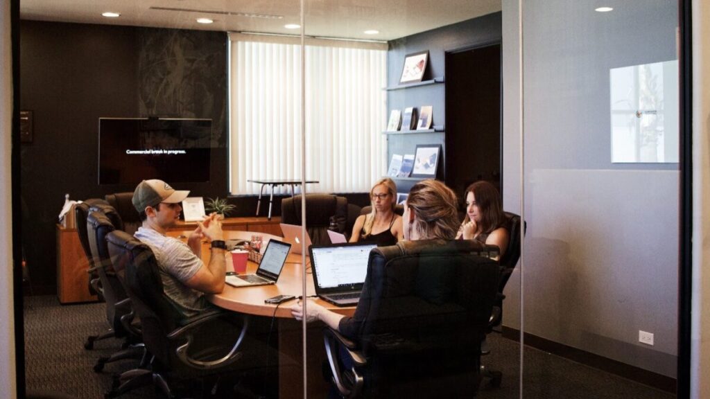 Personen, die sich für ein Business Meeting in einem Konferenzraum treffen.