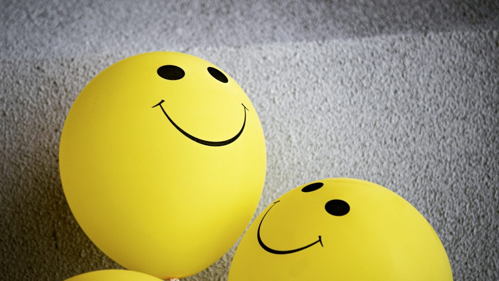 Gelbe Ballons mit einem Smiley darauf.